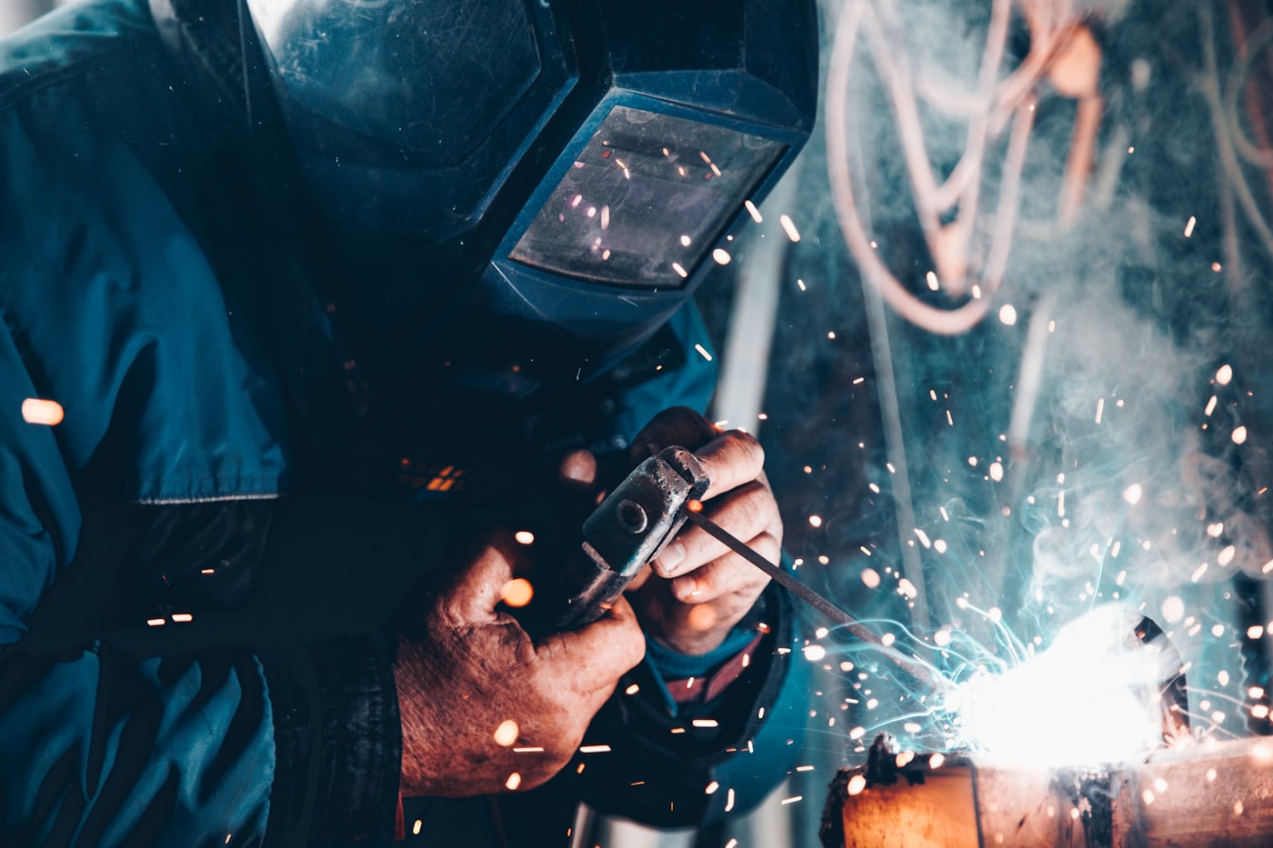 Certified welder joining a steel structure with protective equipment